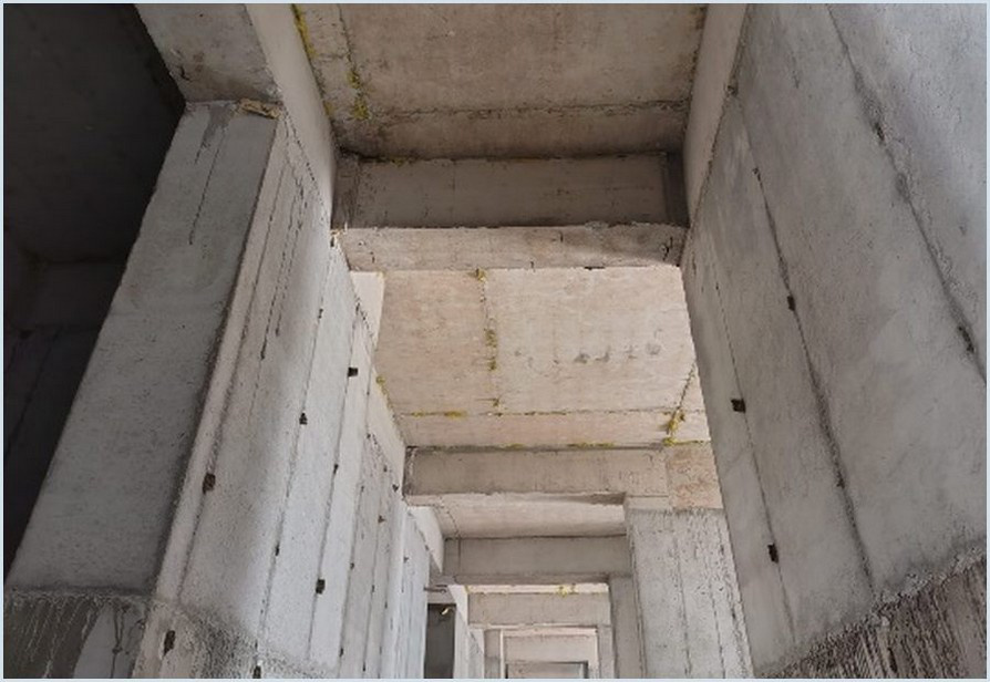 Unfinished concrete beams, walls and slab soffits in a site inspection photograph